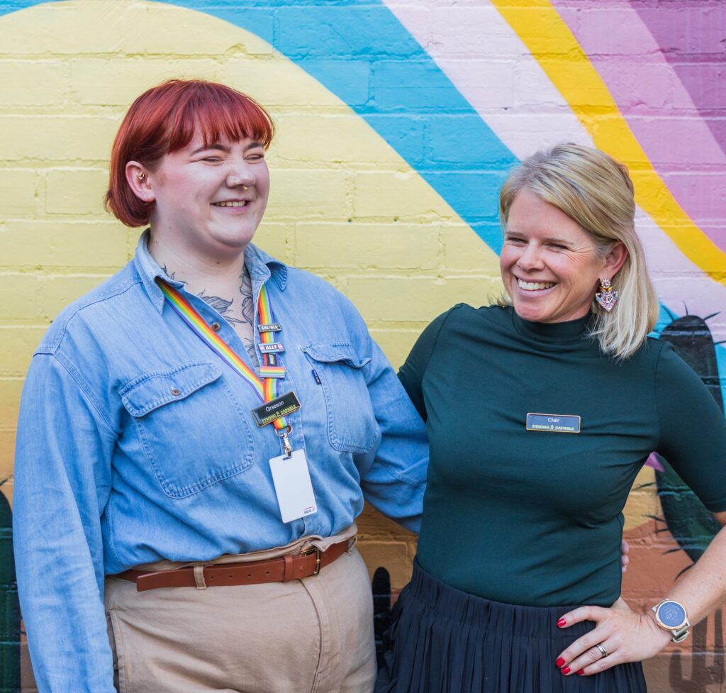 Graeson & Clair laughing in front of a colourful wall